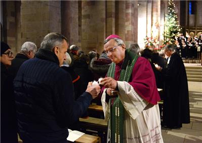 Als Zeichen der Versöhnung geben Bischof Wiesemann (vorne) und Kirchenpräsident Schad das an der Osterkerze entzündete Licht an die Gottesdienstbesucher weiter