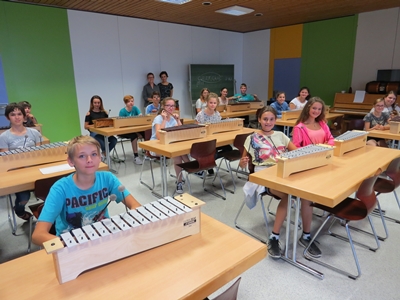 Schulleiterin Elisabeth Kasprowiak (l.) freut sich gemeinsam mit Musiklehrerin Svitlana Weisenburger und der Klasse 8b über die nagelneuen Metallophone
