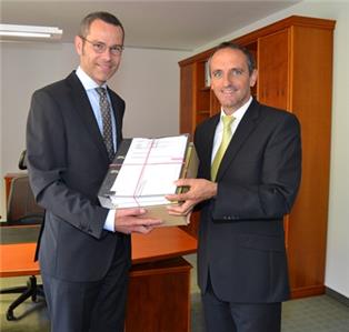 Bürgermeister Dr. Maximilian Ingenthron (links) und Jürgen Büchler, Vorstandsmitglied der VR Bank Südpfalz bei der Übergabe der Baugenehmigung