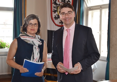 Oberbürgermeister Thomas Hirsch überreicht einer Neubürgerin ihre Einbürgerungsurkunde