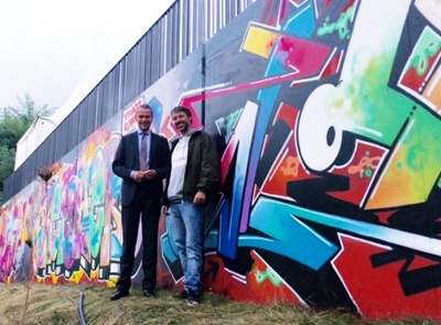 Bei einem Rundgang präsentierte Graffiti-Künstler Till Heim Bürgermeister und Bau- sowie Kulturdezernent Dr. Maximilian Ingenthron das neue Graffiti an der Brücke Süd.