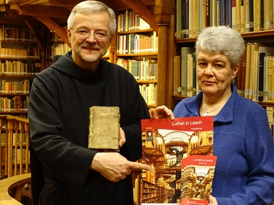 Dr. Annette Gerlach (Landesbibliothekszentrum Rheinland-Pfalz) und Pater Dr. Augustinus Sander OSB (Benediktinerabtei Maria Laach) präsentieren den Flyer der Ausstellung 